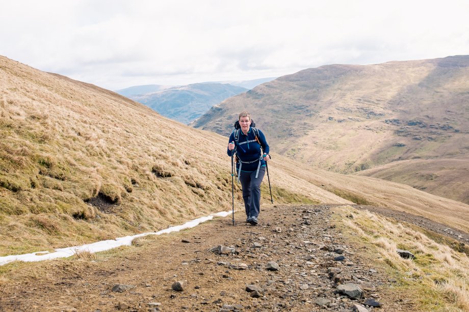 hiker with poles on mountain track
