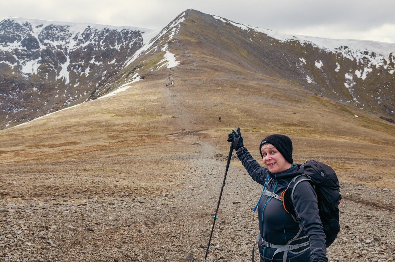 hiker pointing up towards lake distict peak