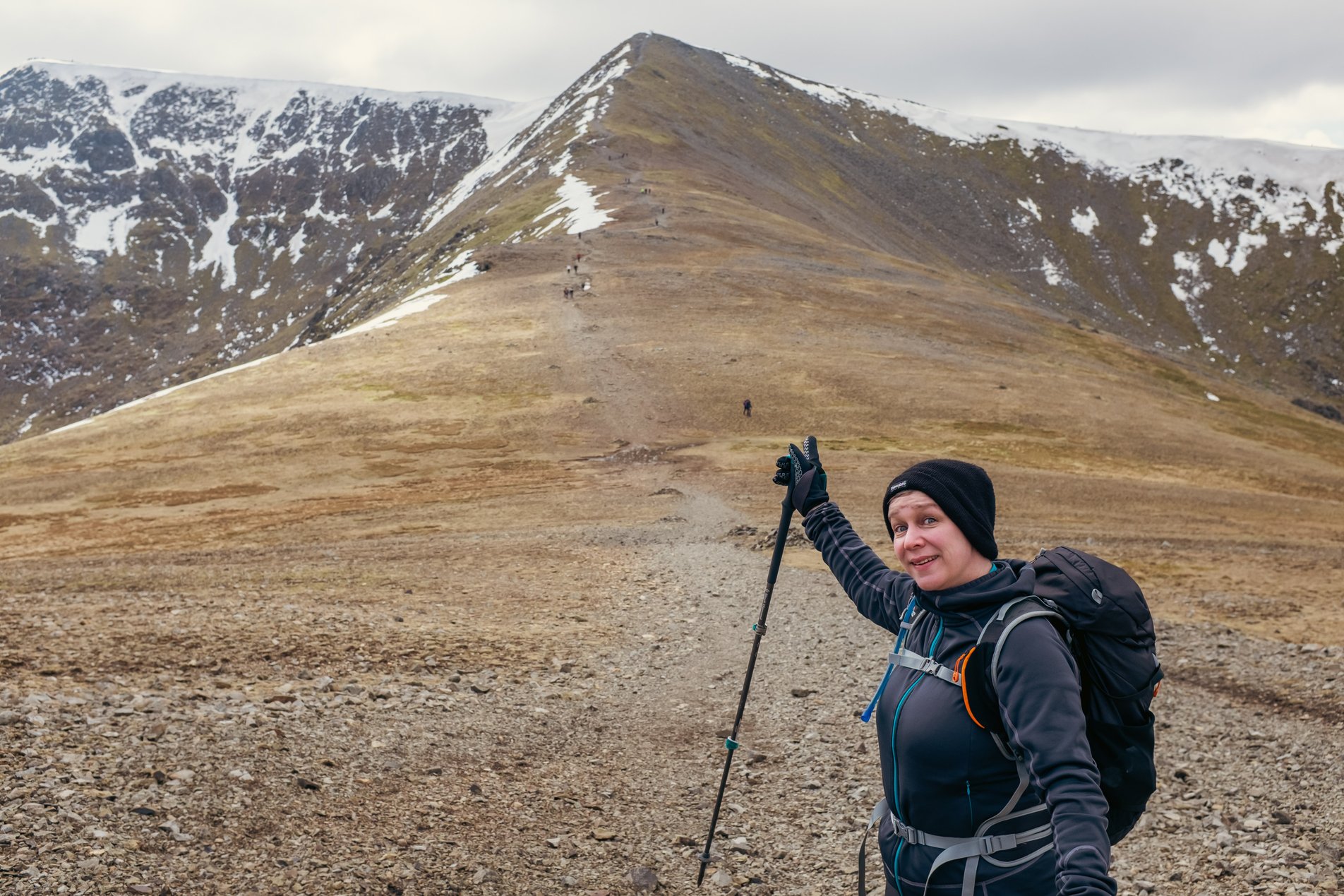 hiker pointing up towards lake distict peak