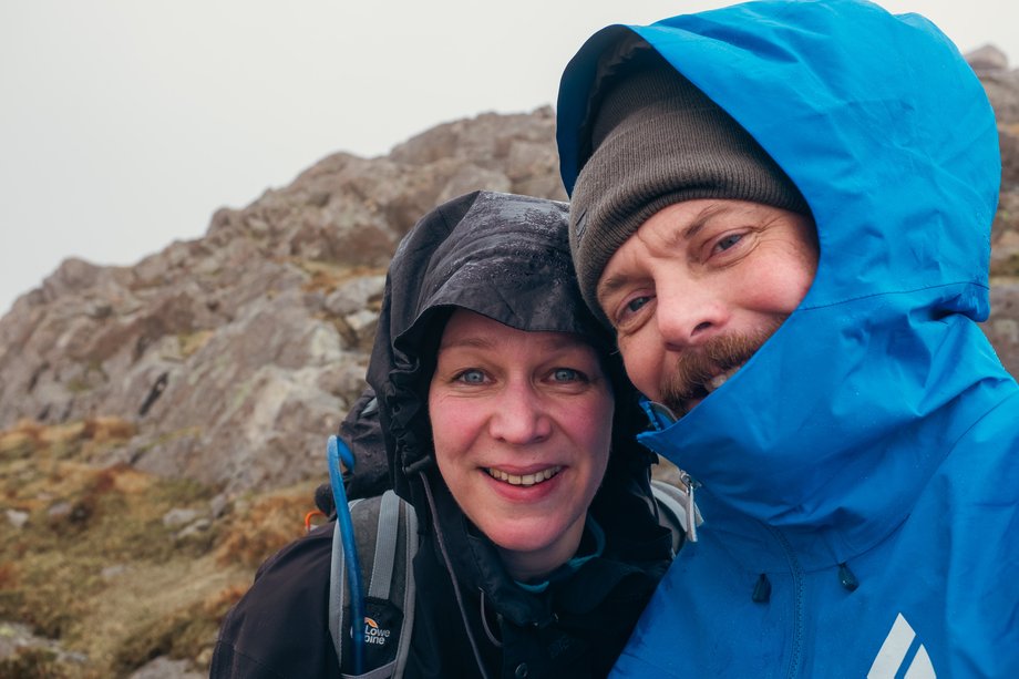two hikers with hoods up against the wind