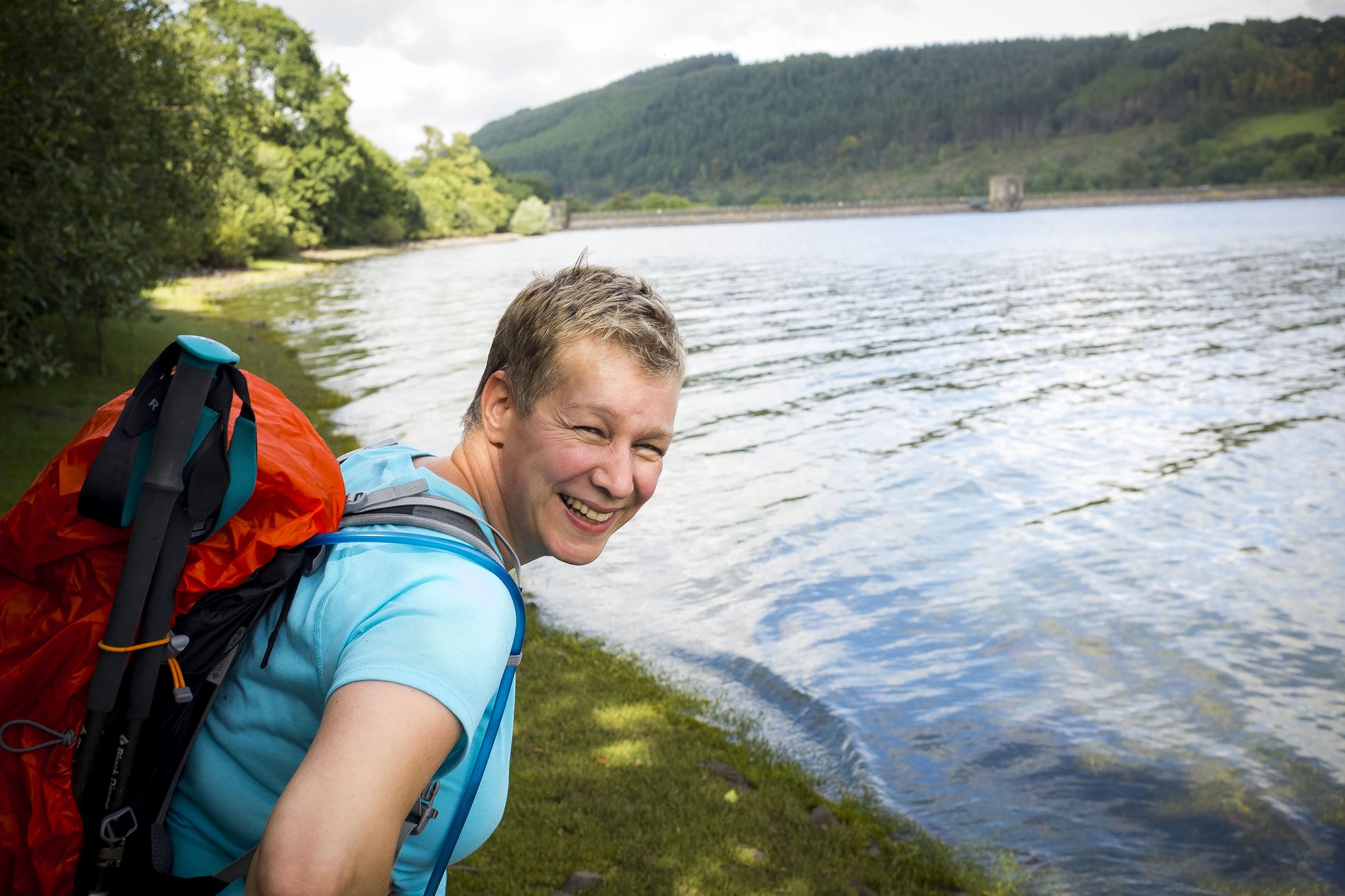 smiling hiker next to reservoir