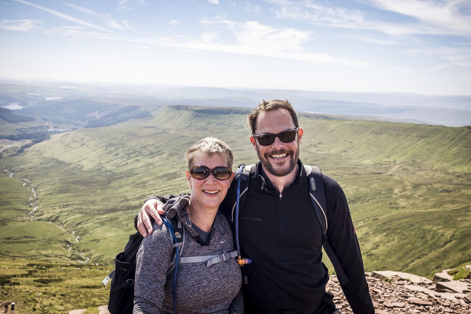 shot of 2 hikers on hill