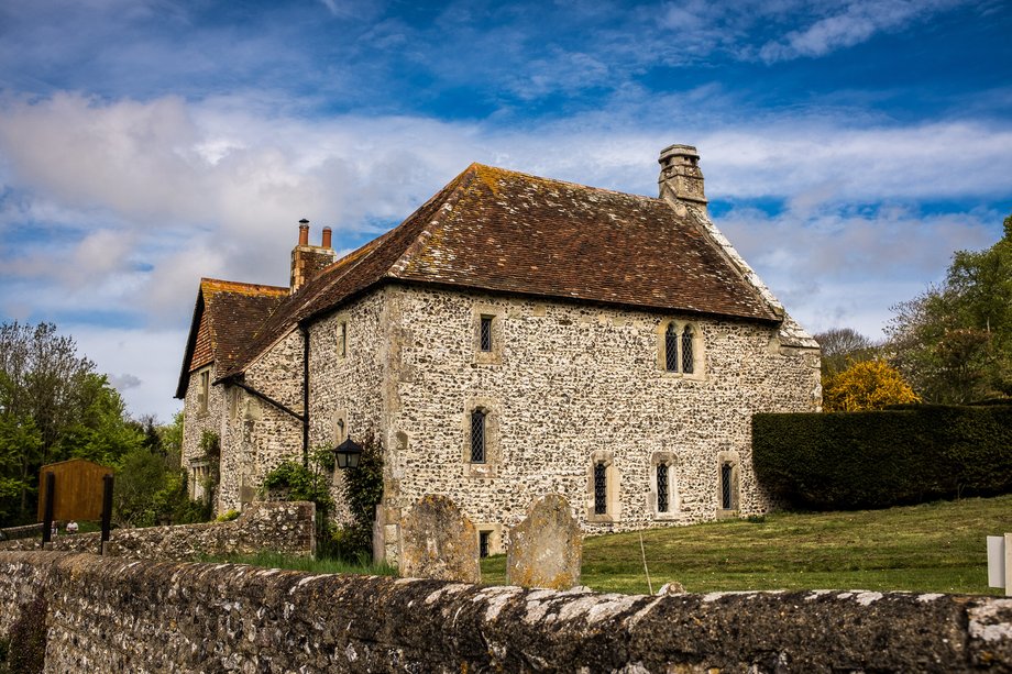 stone and flint house next to graveyard