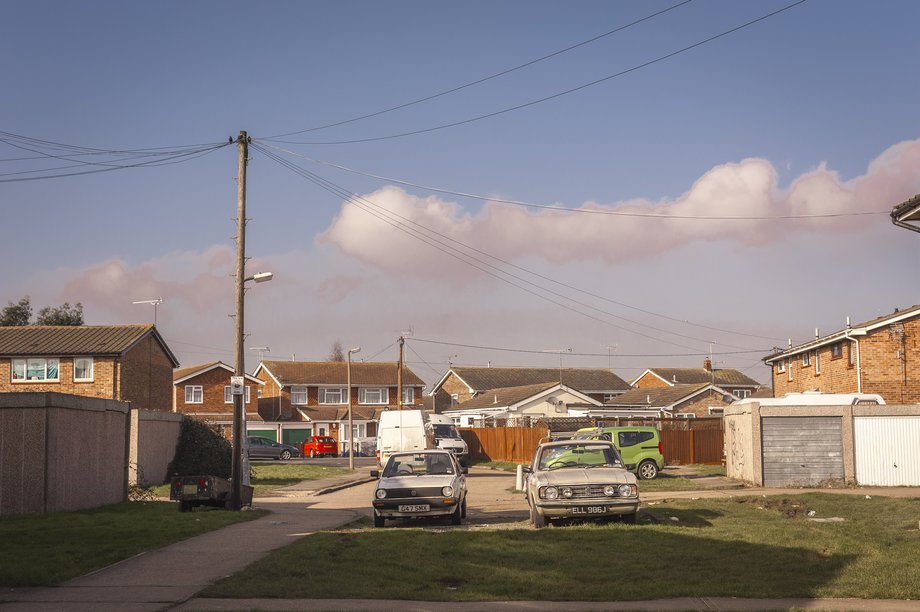 early vw golf and ford cortina parked near lock up garages