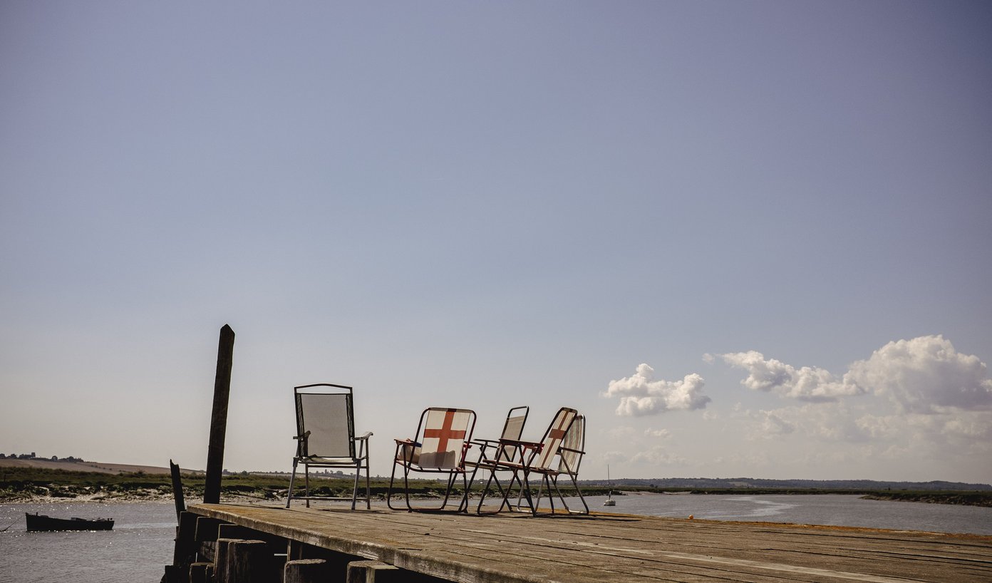 deckchairs with flag of saint george on wooden pier