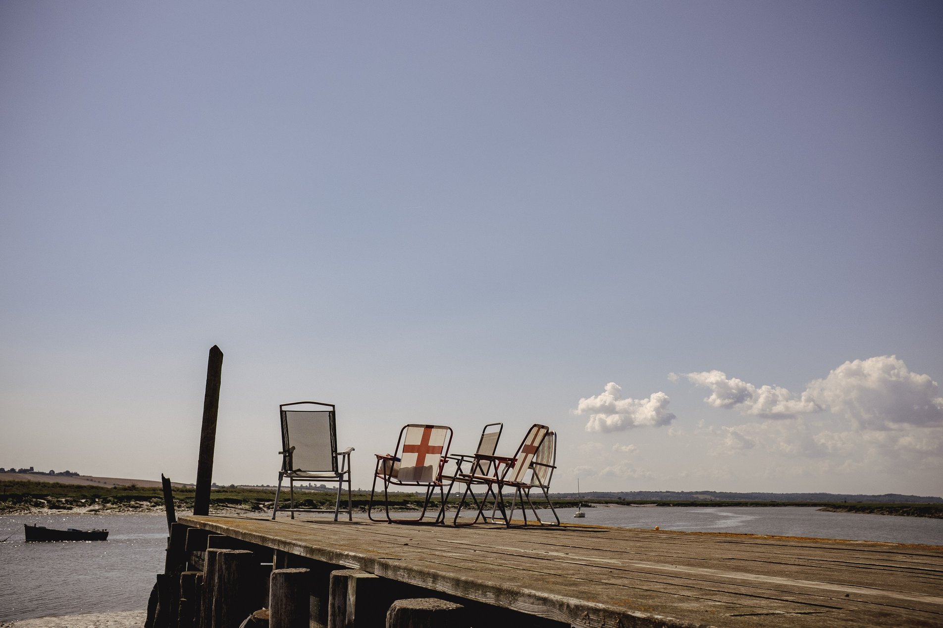 deckchairs with flag of saint george on wooden pier
