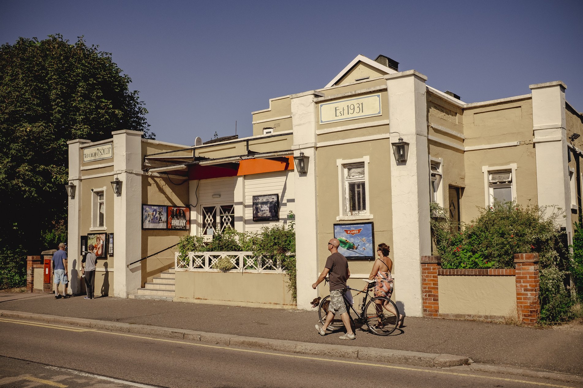art deco cinema building with people walking past