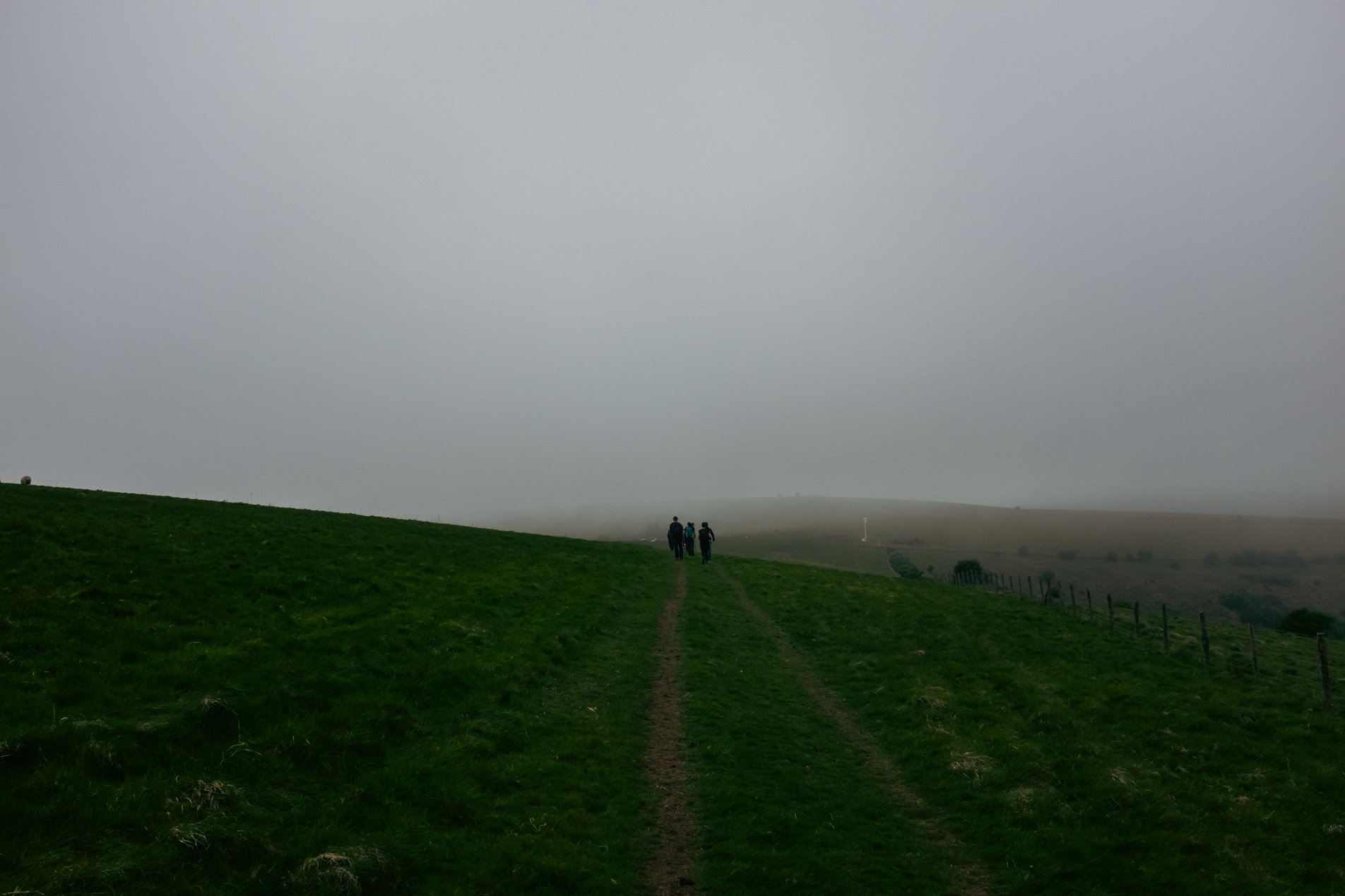 hikers on mist covered hill