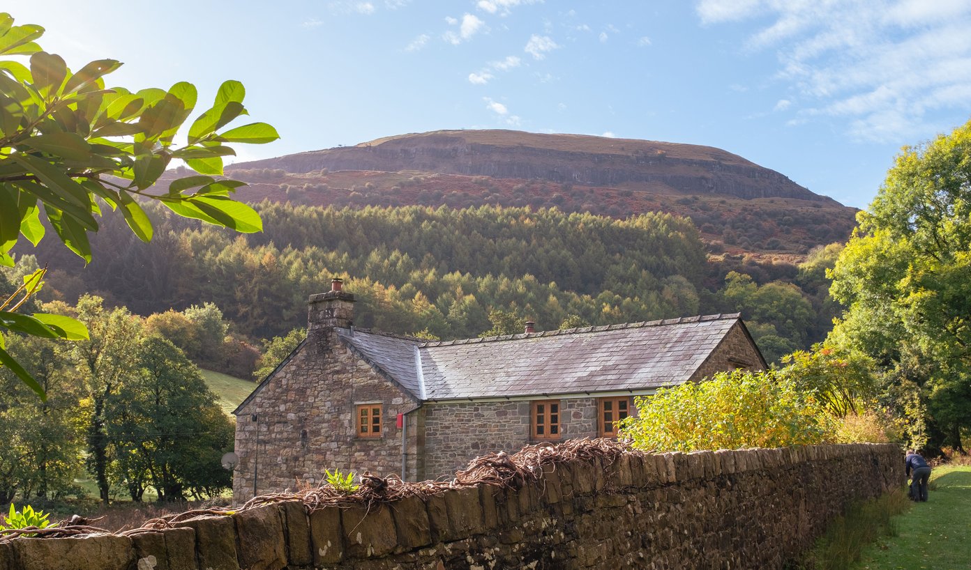 rural cottage with hill and escarpment in background