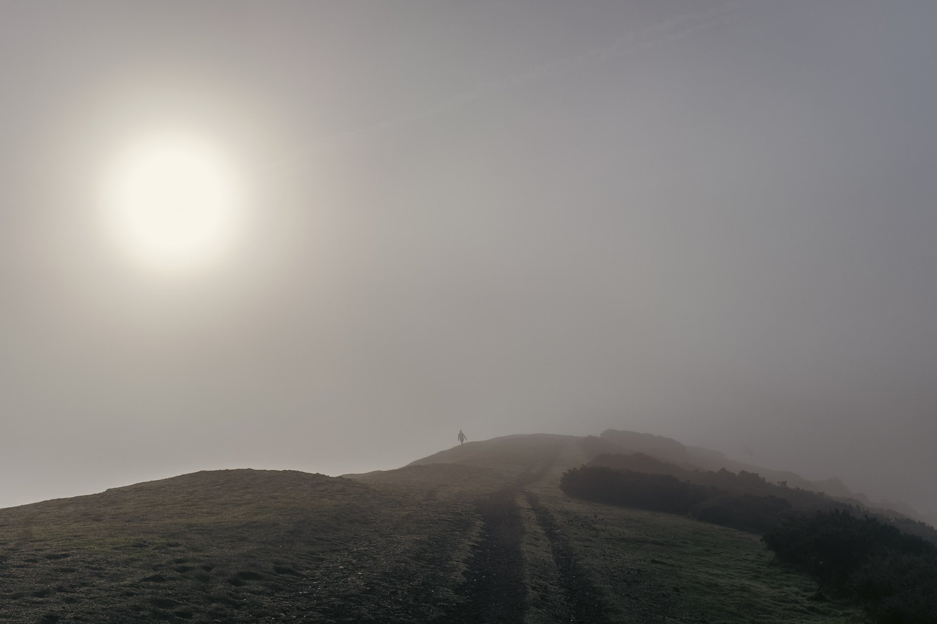 hiker in the morning mist on pinnacle hill in the malverns
