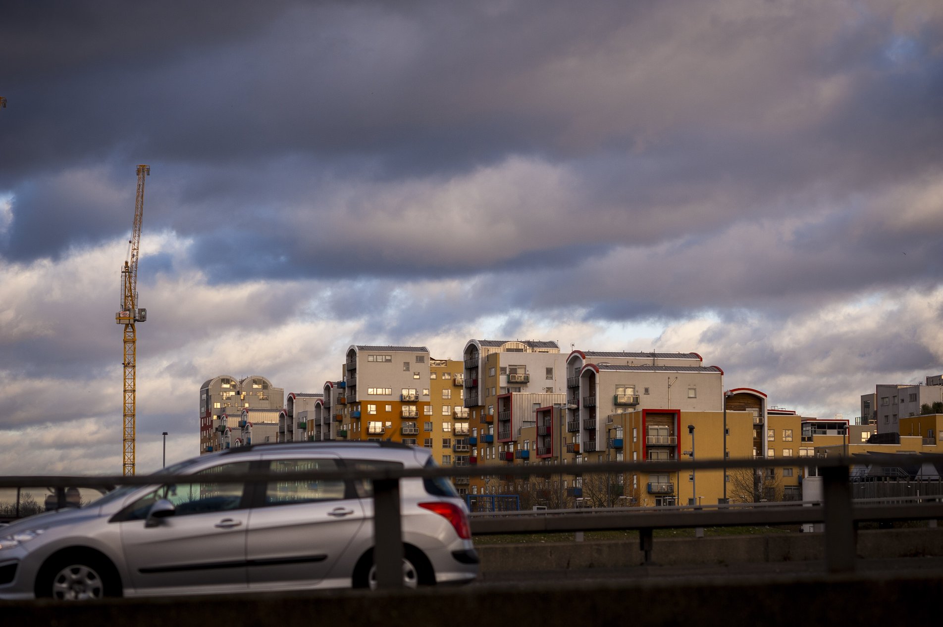 car passing on dual carridgeway in front of flats