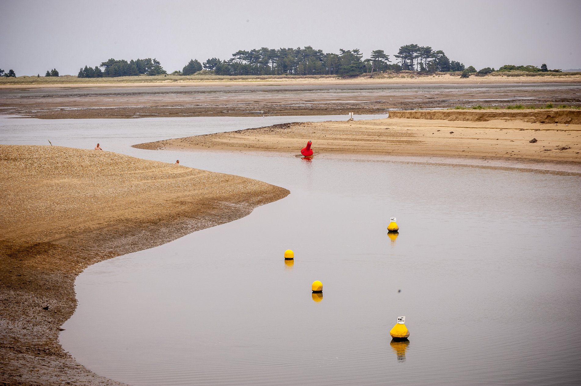 yellow and red buoys in shallow inlet