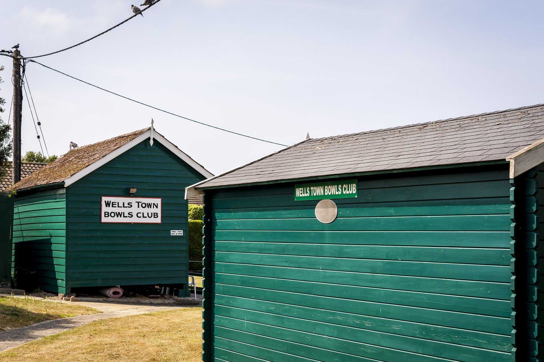 green shuttered huts at wells town bowls club