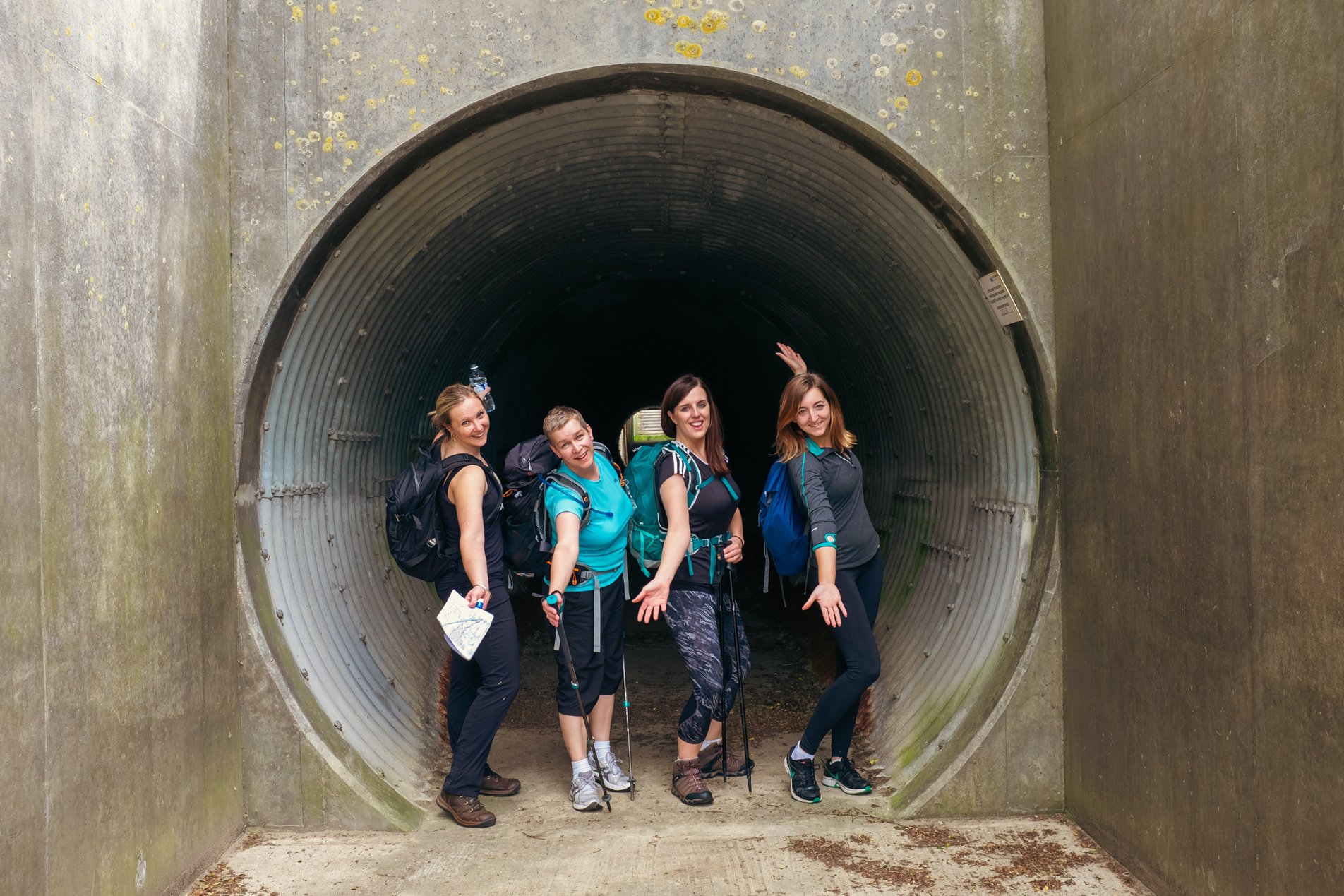 four hikers posing in subway tunnel