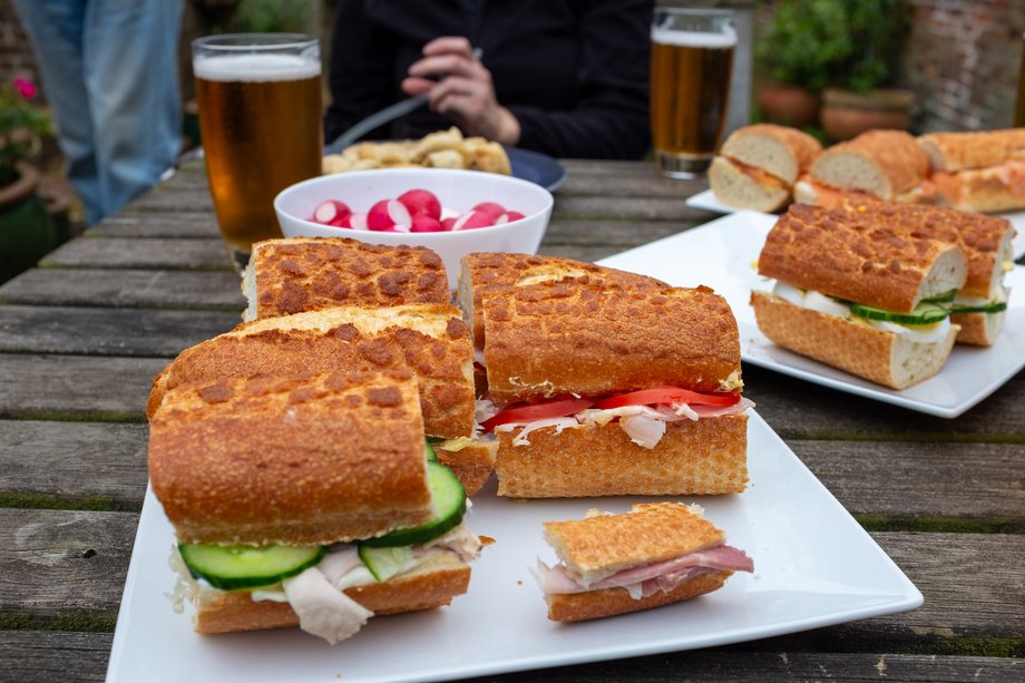 baggettes, radishes and pints of beer on table