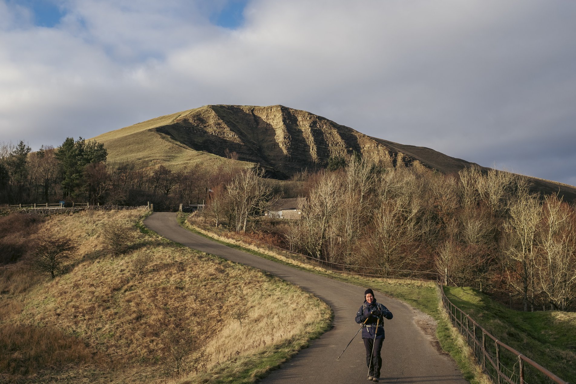 hiker on road with mam tor in background