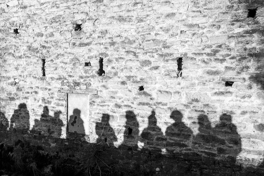 line of shadows of figures on a wall