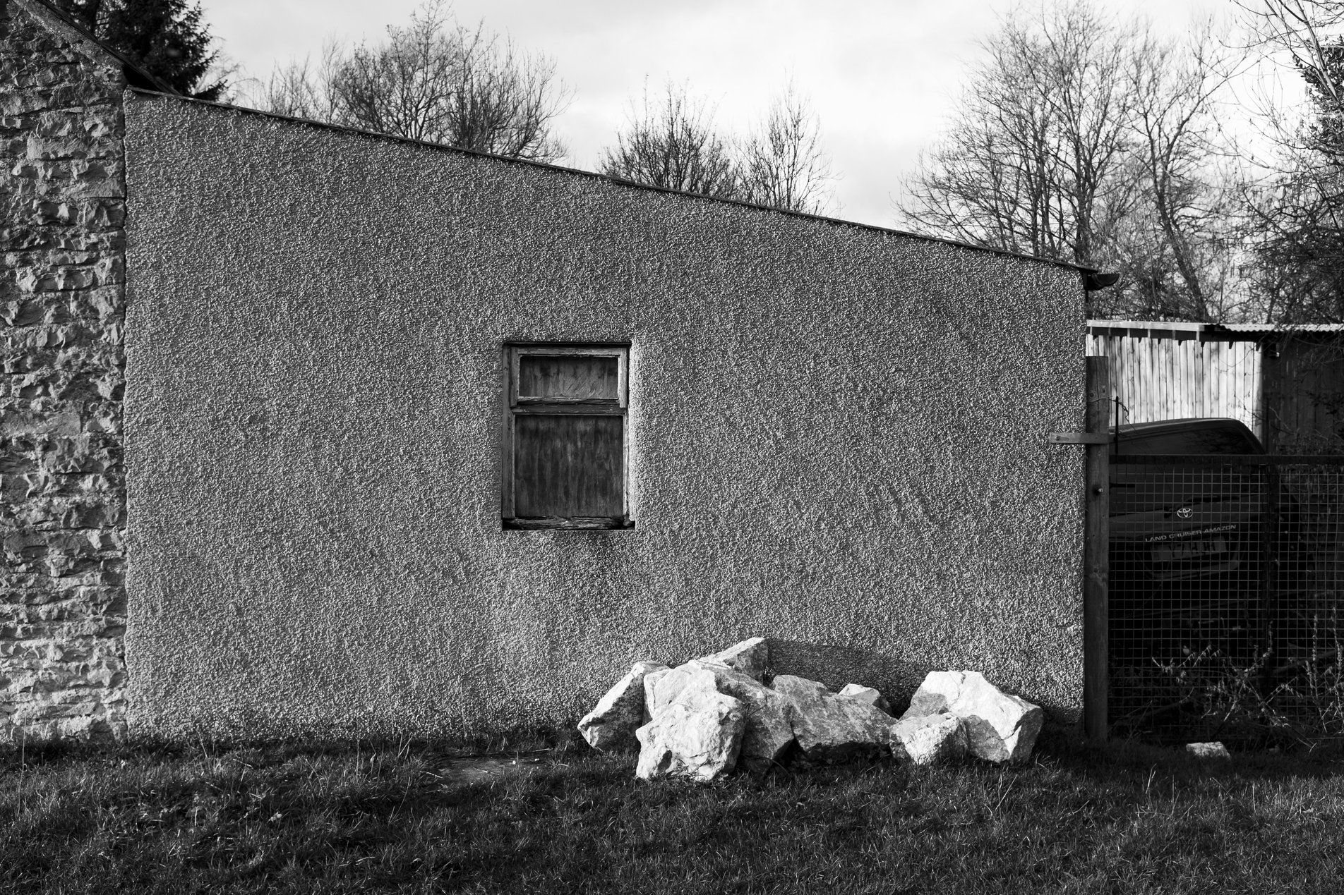 outbuilding with single window and pile of rocks