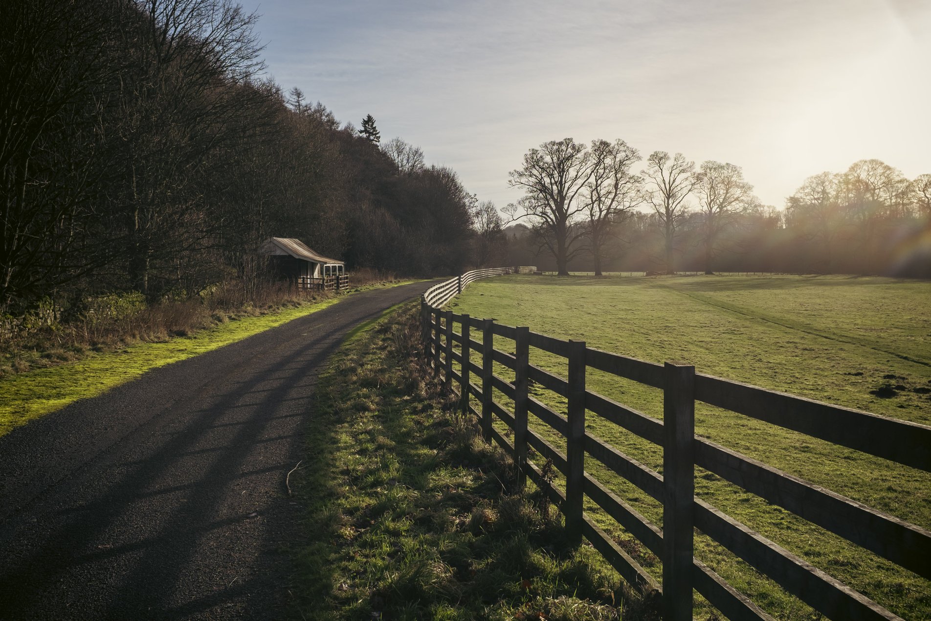 track alongside curved fence with hut