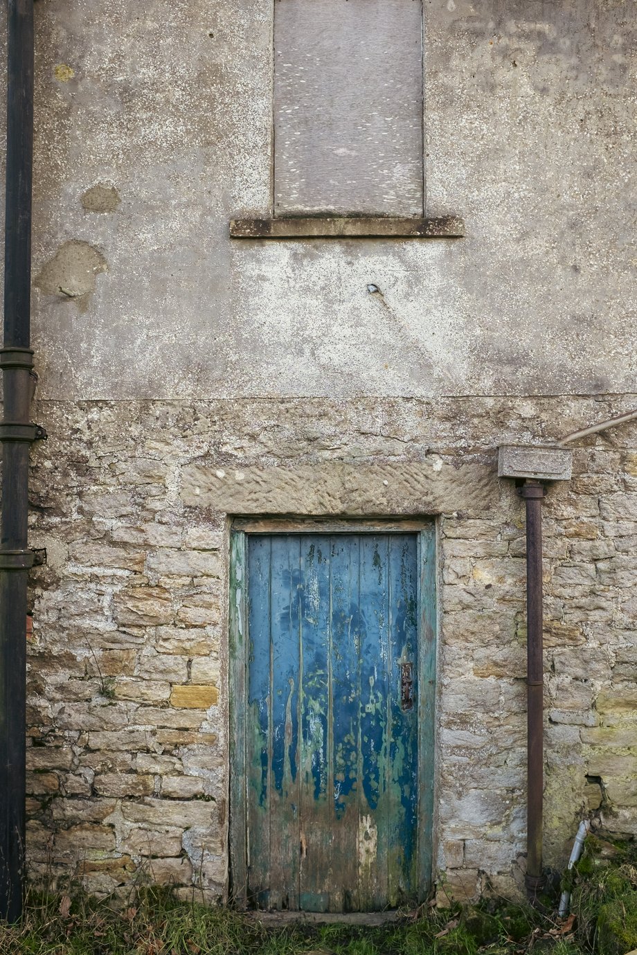 old blue door with flaking paint in stone building