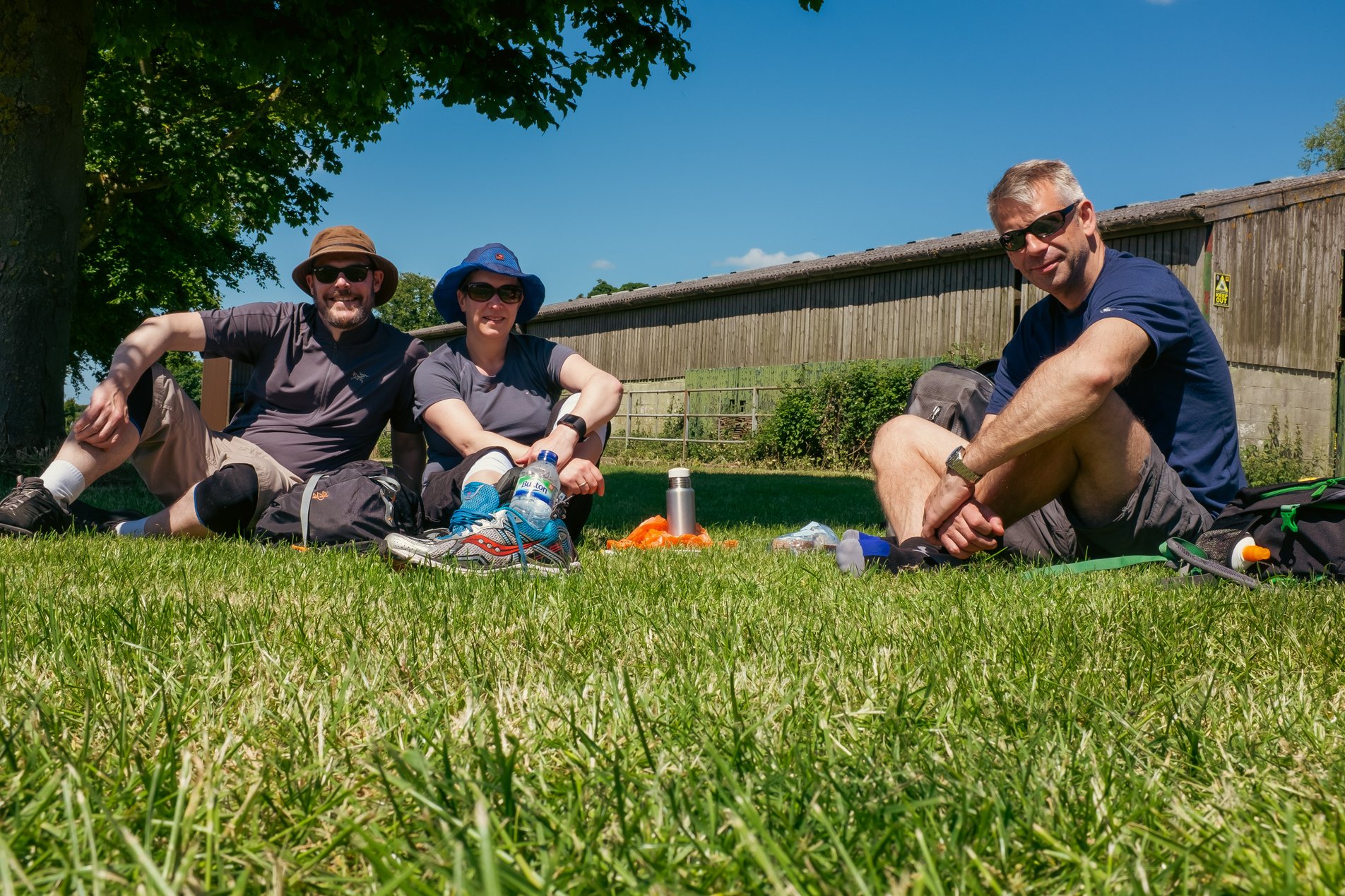 3 hikers sitting on grass