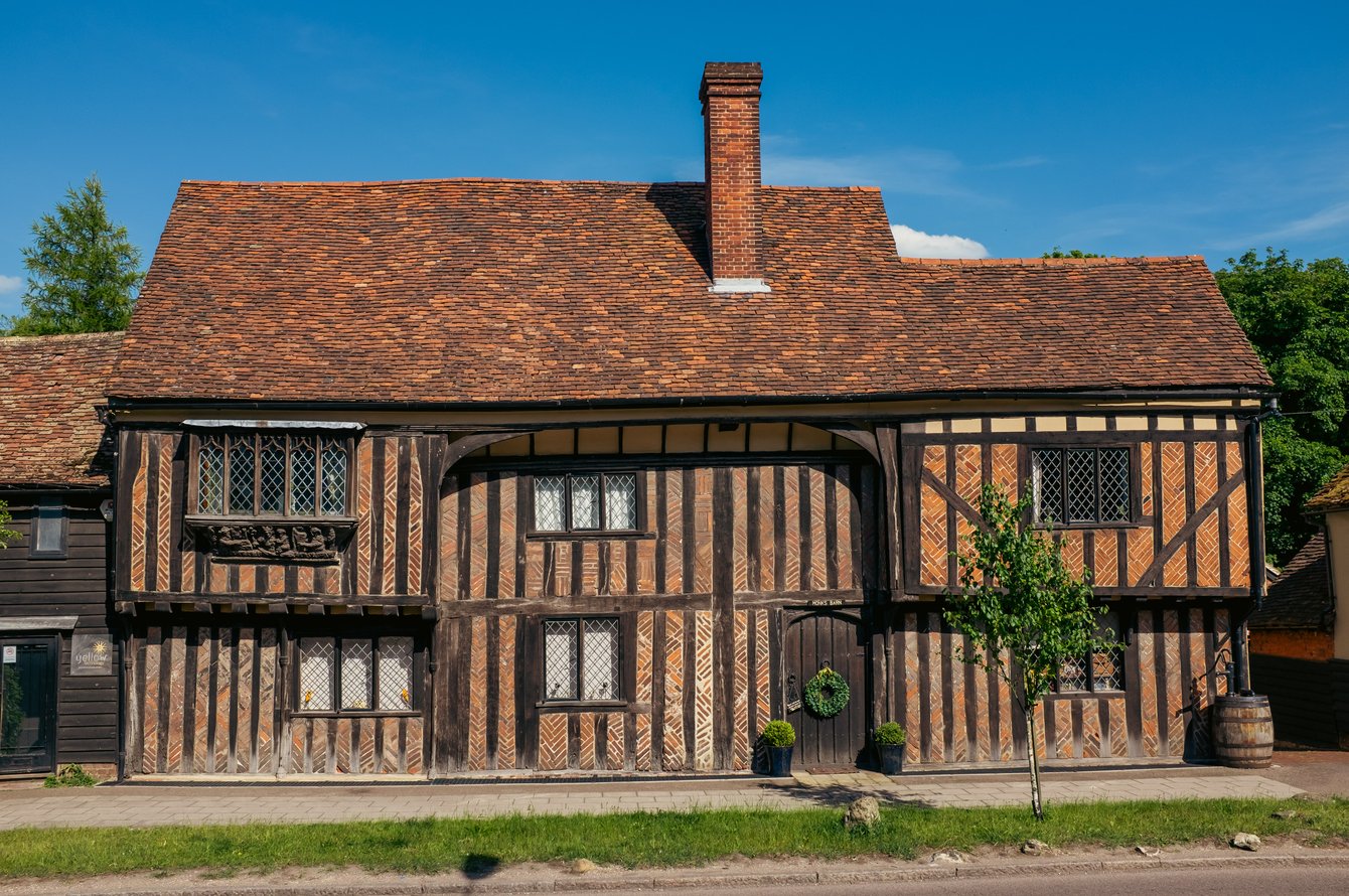 Timber-framed 2 storeyed building with exposed framing and brick nogging on the front.