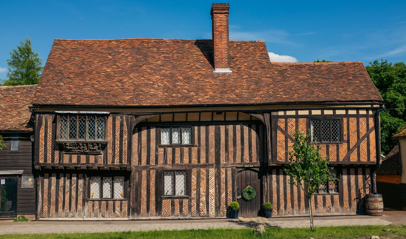 timber-framed 2 storeyed building with exposed framing and brick nogging on the front.