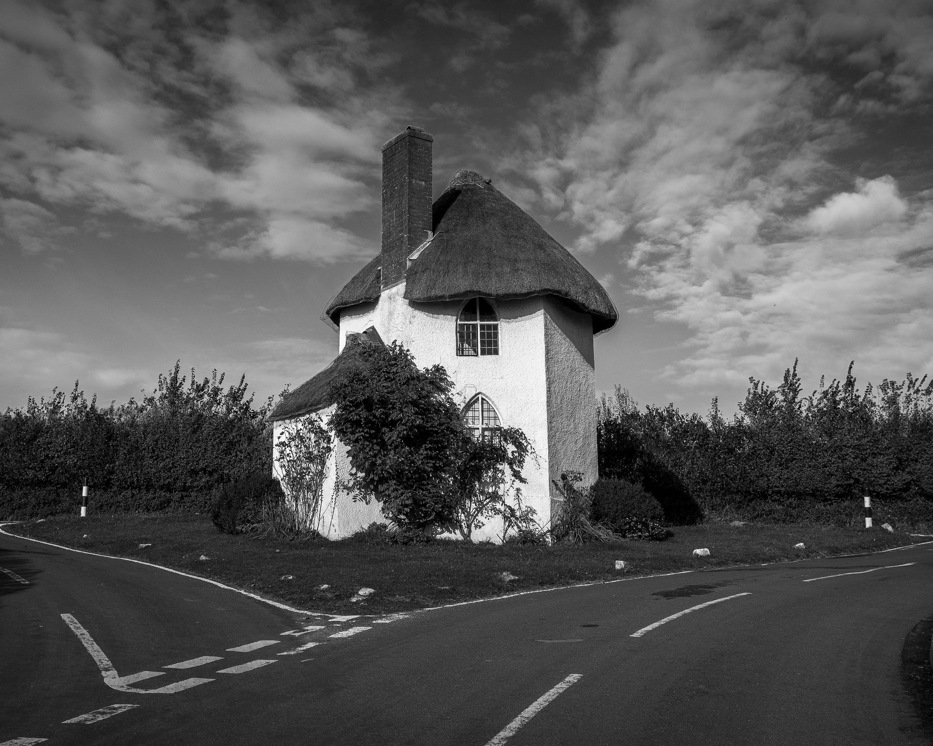 small white thatched cottage on road island