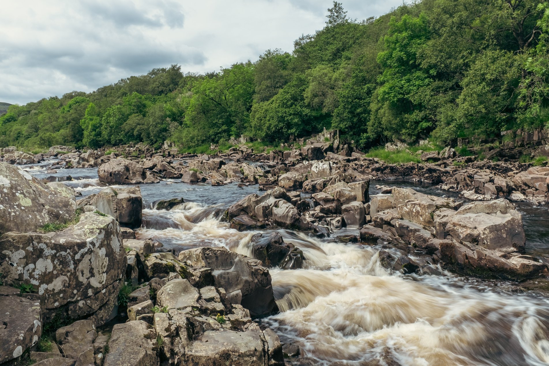 low down shot of fast flowing river with rocks