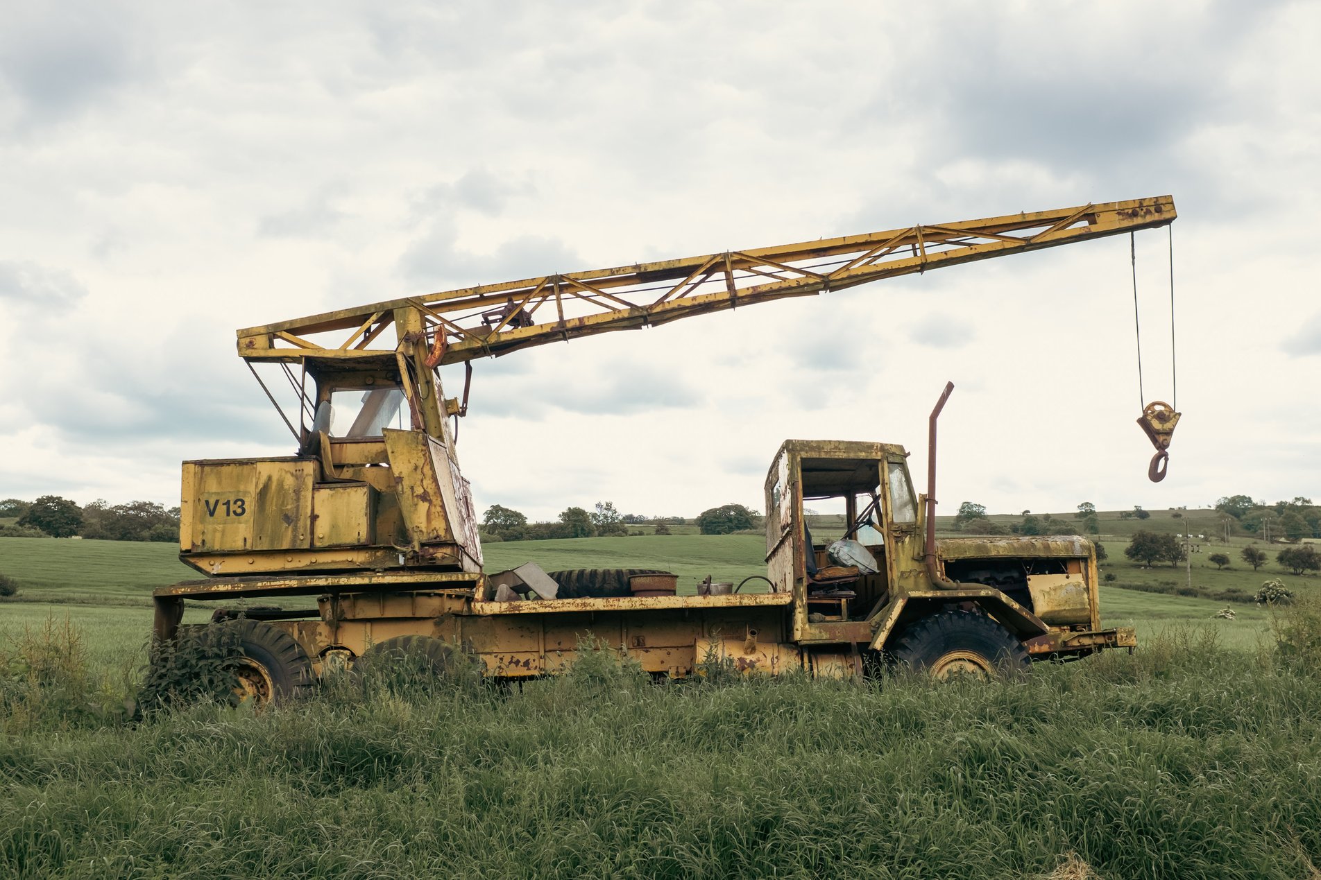 abandonded yellow crane in field
